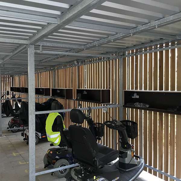 Ruime scootmobiel overkapping met groendak geplaatst bij seniorencomplex