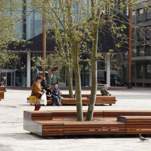 Levendig plein met zitelementen en boombescherming ineen
