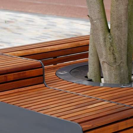 Levendig plein met zitelementen en boombescherming ineen