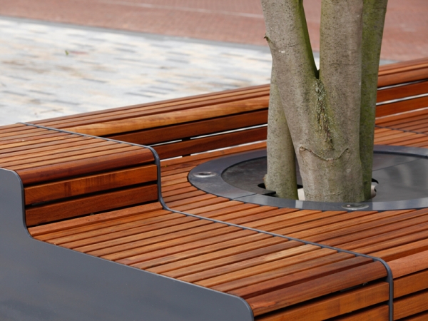 Levendig plein met zitelementen en boombescherming ineen