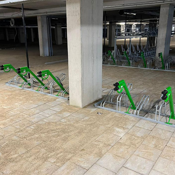 Inrichting fietsenkelder met compacte fietsenrekken en oplaadpunten bij appartementencomplex